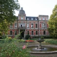 Historisches Schloss mit Grünanlage und zentralem Springbrunnen, umgeben von gepflegtem Park.Historic castle with gardens and central fountain, surrounded by a well-kept park.Historisk slot med have og centralt springvand, omgivet af en velplejet park.Historisch kasteel met tuinen en centrale fontein, omgeven door een goed onderhouden park.