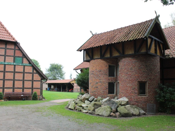 Historischer Hof in Warmsen mit Backsteingebäude, Fachwerk, Garten und gepflastertem Hofeingang.