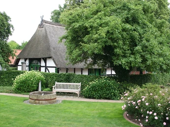 Spargelmuseum Nienburg Traditionelles Fachwerkhaus mit Reetdach, umgeben von üppigem Grün und gepflegten Gärten in Nienburg.Traditional half-timbered house with thatched roof, surrounded by lush greenery and well-tended gardens in Nienburg.Traditionelt bindingsværkshus med stråtag, omgivet af frodigt grønt og velplejede haver i Nienburg.Traditioneel vakwerkhuis met rieten dak, omgeven door weelderig groen en goed onderhouden tuinen in Nienburg.