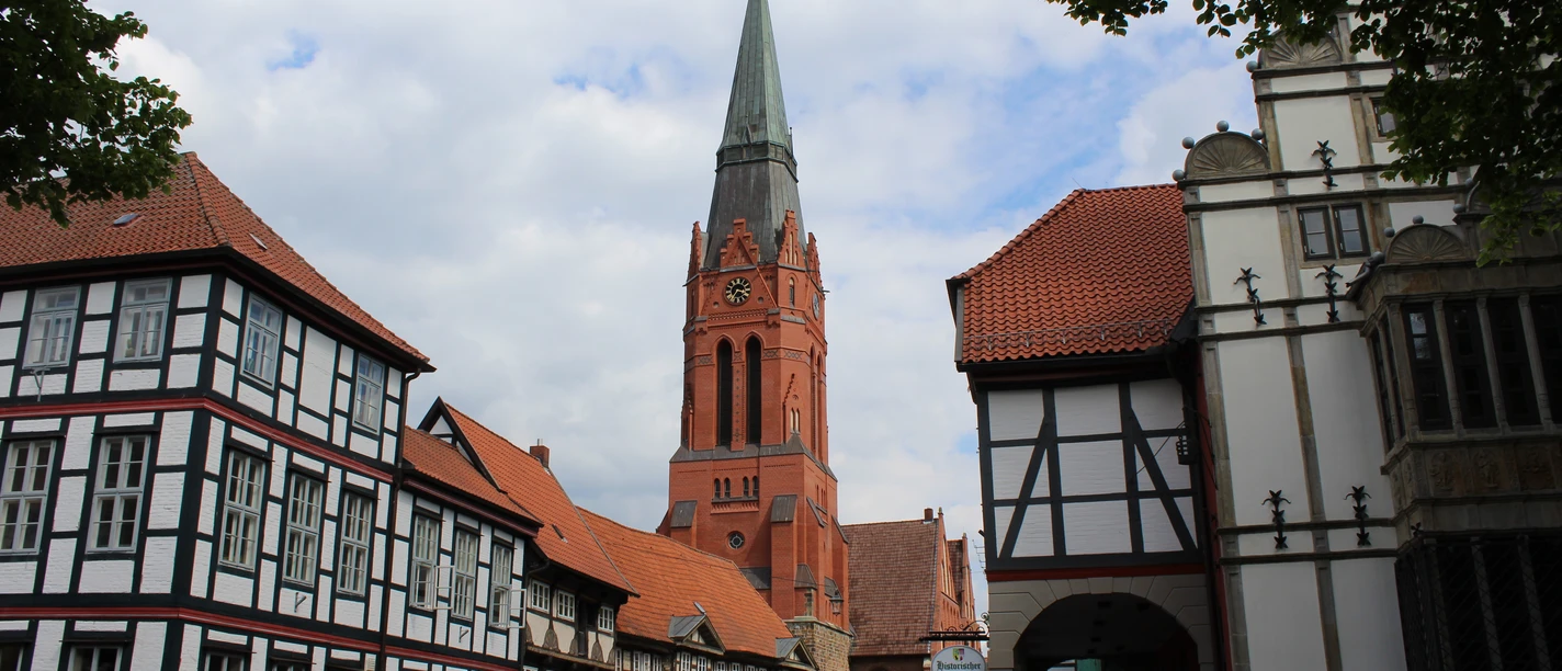 Pfarrkirch St. Martin in Nienburg Parish church of St. Martin in Nienburg surrounded by half-timbered buildings, under a cloudy sky.