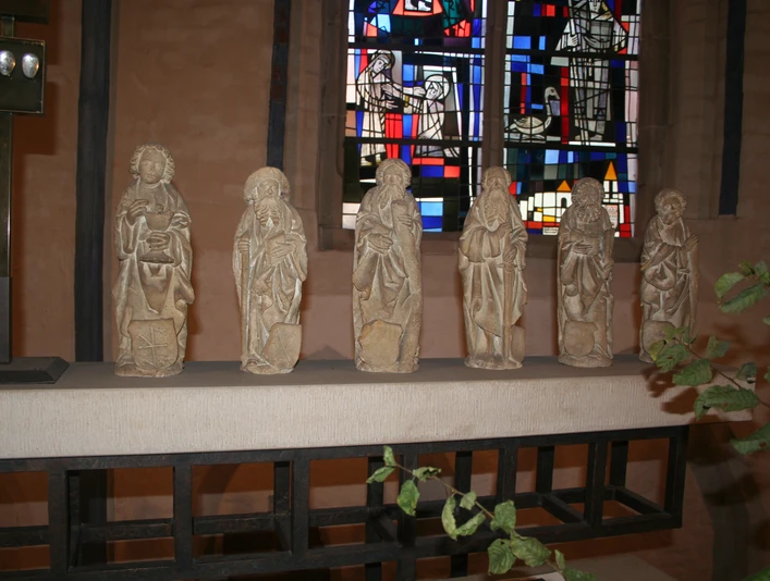Apostelfiguren in St. Martin Nienburg Sechs steinerne Apostelfiguren stehen in einer Kirchenreihe vor farbigem Glasfenster in Nienburg.Six stone apostle figures stand in a row in front of a stained glass window in Nienburg.Seks apostelfigurer af sten står på rad og række foran et vindue af farvet glas i Nienburg.Zes stenen apostelfiguren staan op een rij voor een gekleurd glazen raam in Nienburg.