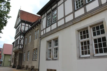 Altes Amtsgericht Petershagen Fachwerkgebäude mit weißen und grauen Wänden sowie roten Dachziegeln und vielen Fenstern in Petershagen.