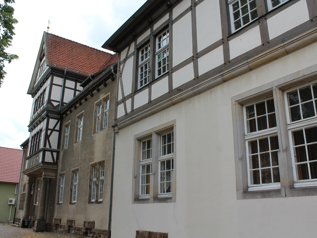 Altes Amtsgericht Petershagen Fachwerkgebäude mit weißen und grauen Wänden sowie roten Dachziegeln und vielen Fenstern in Petershagen.