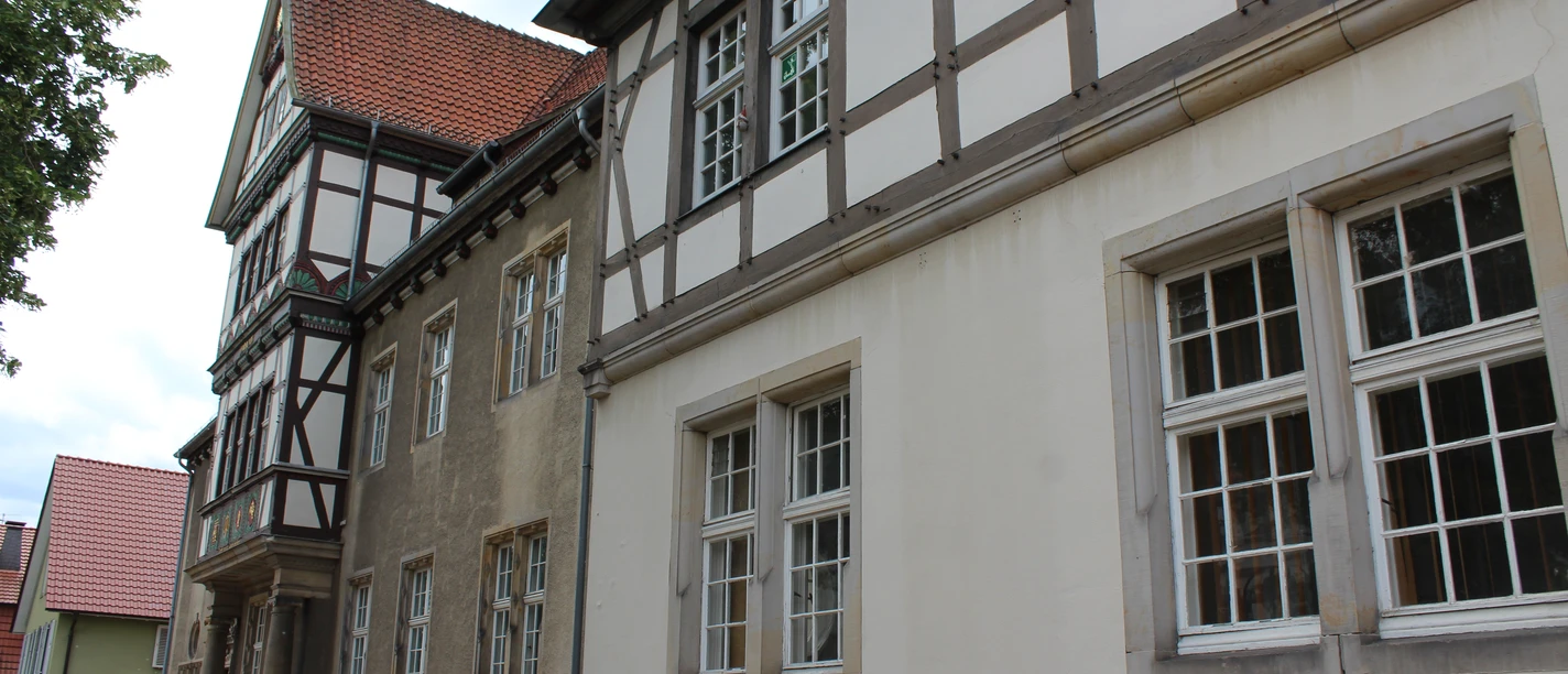 Altes Amtsgericht Petershagen Fachwerkgebäude mit weißen und grauen Wänden sowie roten Dachziegeln und vielen Fenstern in Petershagen.