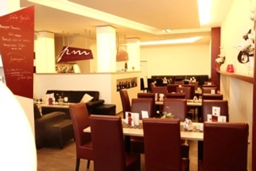 image Ein elegantes Restaurant mit roten Lederstühlen und gedeckten Tischen in einer modernen Atmosphäre.
