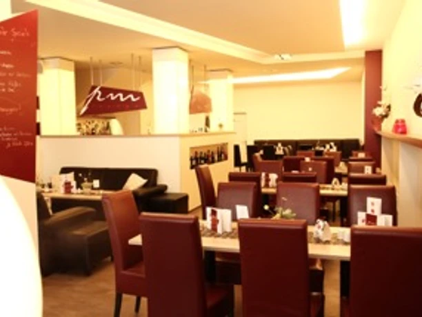 image Ein elegantes Restaurant mit roten Lederstühlen und gedeckten Tischen in einer modernen Atmosphäre.