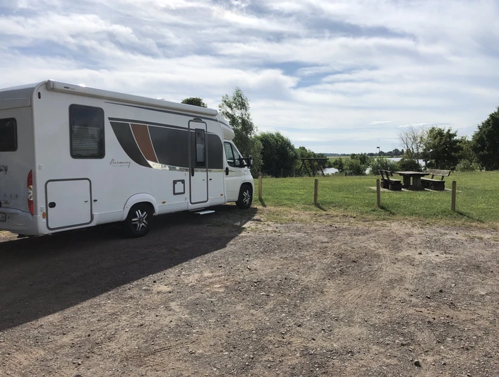 Wohnmobistellplatz mit malerischem Blick auf Flusslandschaft und reichlich Platz im Grünen.