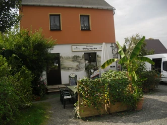 Two-storey building with restaurant Voigtsgrün, possibly rural surroundings.