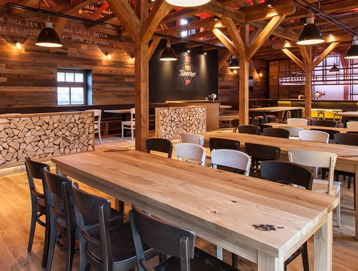 Köstritzer Brauerei Gutshof Innenansicht eines rustikalen Brauhauses mit Holzbalken und langen Holztischen.Interior view of a rustic brewery with wooden beams and long wooden tables.Pohled do interiéru rustikálního pivovaru s dřevěnými trámy a dlouhými dřevěnými stoly.Widok wnętrza rustykalnego browaru z drewnianymi belkami i długimi drewnianymi stołami.Interieur van een rustieke brouwerij met houten balken en lange houten tafels.Vista interna di una birreria rustica con travi in legno e lunghi tavoli in legno.
