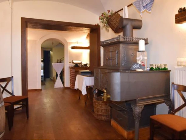 Museumskeller Reichenbach Ein traditioneller Raum mit Holzböden, Ofen und rustikalen Holzmöbeln in warmen Tönen.