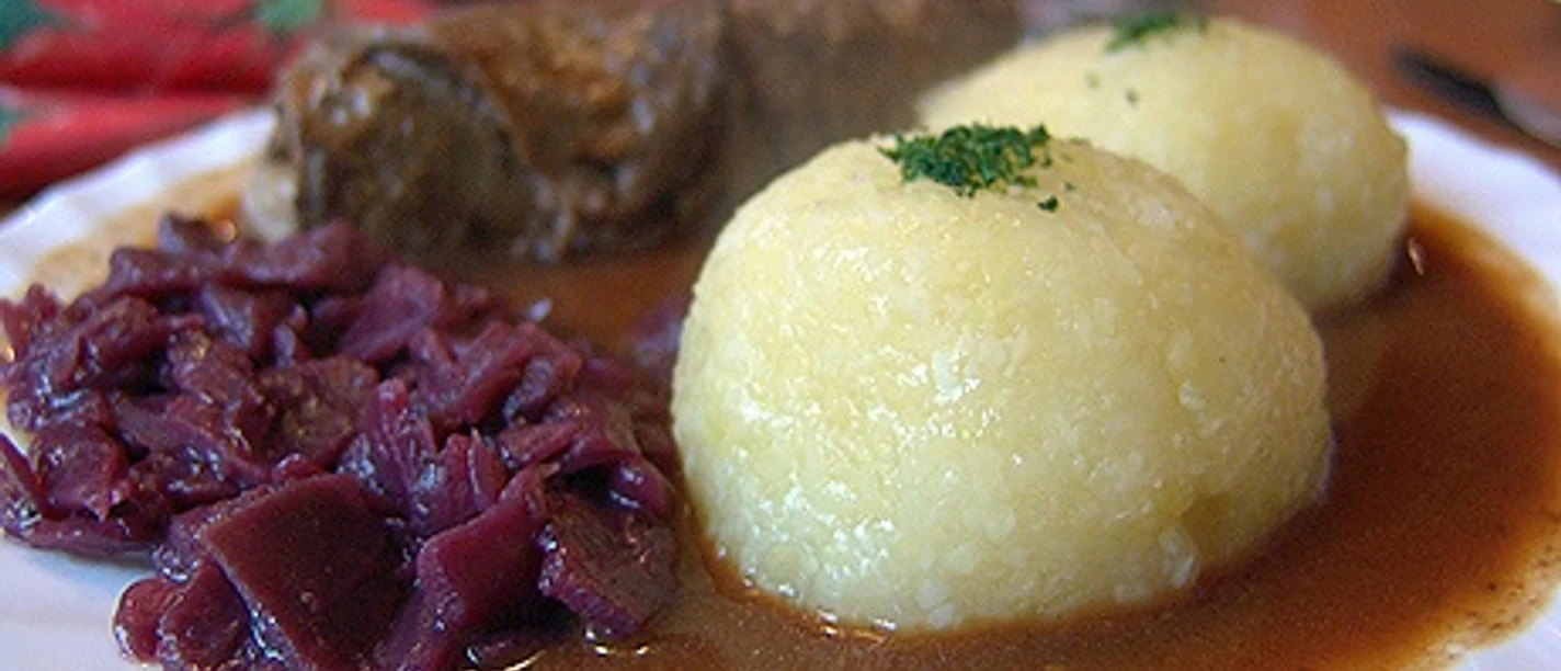 Roulade with two potato dumplings, served with red cabbage in a hearty roast jus.
