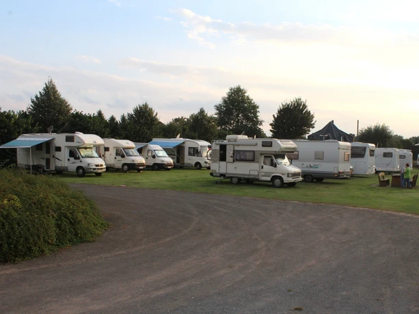 Wohnmobilstellplatz Bruchhausen-Vilsen Wohnmobilstellplätze in Bruchhausen-Vilsen auf grünem Rasen, umgeben von Bäumen und Sträuchern.