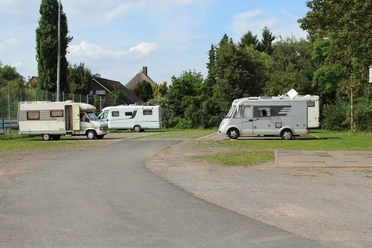 Wohnmobilstellplatz Petershagen Wohnmobilstellplatz in Petershagen mit mehreren geparkten Wohnmobilen, umgeben von Bäumen und Grünflächen.