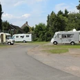 Wohnmobilstellplatz Petershagen Wohnmobilstellplatz in Petershagen mit mehreren geparkten Wohnmobilen, umgeben von Bäumen und Grünflächen.