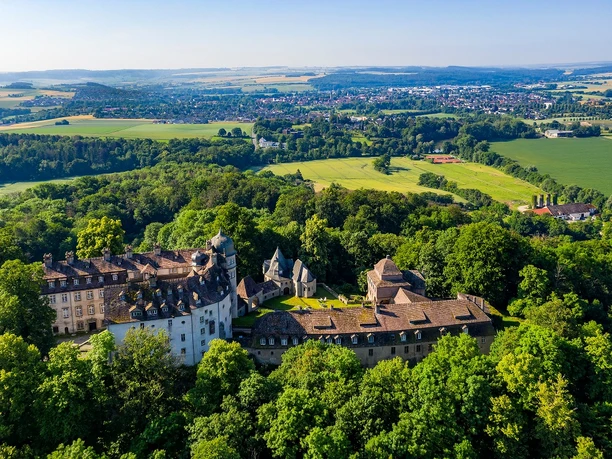 Hinnenburg Luftaufnahme der historischen Hinnenburg, die von üppigem Grün umgeben auf einer Anhöhe thront.