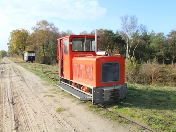 Moorbahn Uchte Die Moorbahn Uchte fährt auf schmalen Gleisen durch eine herbstliche Moorlandschaft unter blauem Himmel.