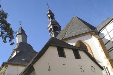Kloster Wiedenbrück Historische Kirche mit markantem Glockenturm und blendend weißen Fassaden unter klarem Himmel.