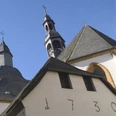 Kloster Wiedenbrück Historische Kirche mit markantem Glockenturm und blendend weißen Fassaden unter klarem Himmel.