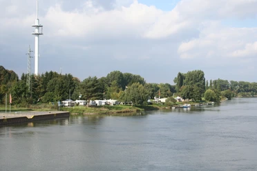 Campingplatz Stolzenau Am Flussufer des Weserflusses gelegener Campingplatz, umgeben von grüner Natur und Bäumen.