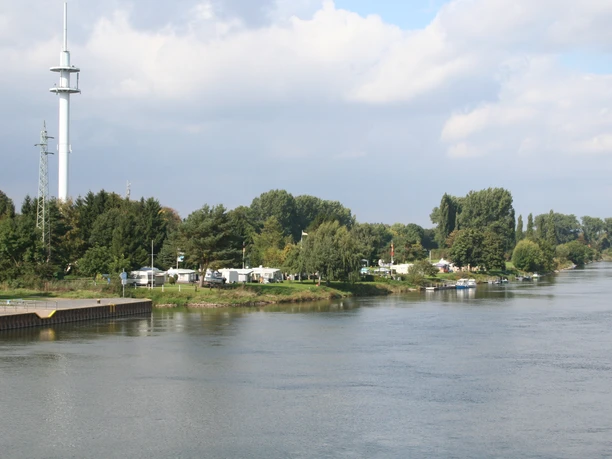 Campingplatz Stolzenau Am Flussufer des Weserflusses gelegener Campingplatz, umgeben von grüner Natur und Bäumen.