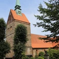 St. Cyriakuskirche Bruchhausen Backstein-Kirche mit grünem Turm, eingebettet in üppiges Grün; architektonisches Erbe.