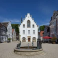 Rathaus der Stadt Brakel Rathaus von Brakel mit Giebel-Spitzdach, umgeben von historischen Gebäuden, zentraler Brunnen.