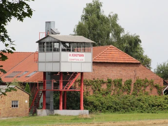 Alte Kartoffeldämpfanlage H. Kuhlmann mit rotem Dach, umgeben von ländlicher Vegetation in Stöckse.