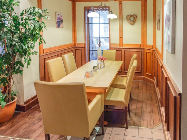 Gaststätte Timmer innen_KHB_8781.jpg Innenraum mit Holzwandverkleidung, hellem Holztisch, sechs beigen Stühlen und Blumen auf dem Tisch