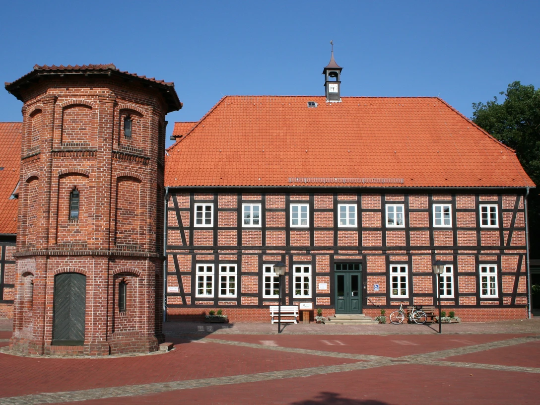 Packhaus Thedinghausen Historisches Fachwerkgebäude mit rotem Ziegeldach und Turmanbau auf einem gepflasterten Platz.