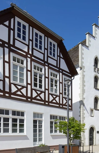 Alte Waage Historisches Fachwerkhaus und Giebelhaus aus weißem Putz im Sonnenschein, Teil eines Altstadtensembles.