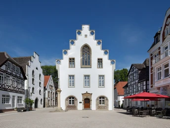 Weißes Rathaus im Stil der Weserrenaissance in Brakel mit dekorativen Stufengiebeln und Spitzfenster.