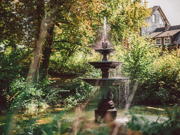 Een grote fontein in de Einbeck Stiftsgarten in de zomer.