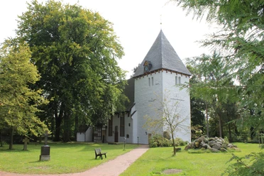 Danielskirche Lavelsloh Die Danielskirche in Lavelsloh liegt umgeben von Natur, mit einem markanten Turm und gepflegtem Grün.