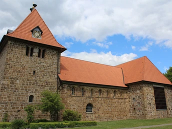 Kirche Wietzen Die Wietzener Kirche präsentiert sich mit ihrem markanten, roten Ziegeldach und robustem Steinturm.