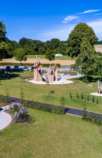 Ludowinengarten in Bökendorf Spielplatz im Ludowinengarten Bökendorf, umgeben von grüner Landschaft und blühenden Beeten.