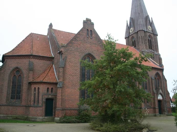 Backsteinkirche Leese mit markantem Turm aus dem 19. Jahrhundert; umgeben von Grün an einem ruhigen Ort.