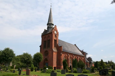 Kirche St. Georg in Eitzendorf Backsteinkirche St. Georg in Eitzendorf mit markantem Turmspitz, umgeben von grüner Landschaft.