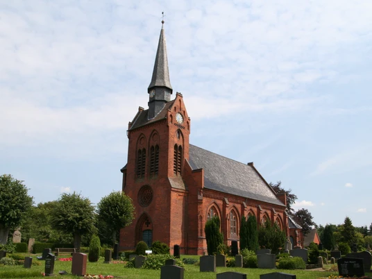 Kirche St. Georg in Eitzendorf Backsteinkirche St. Georg in Eitzendorf mit markantem Turmspitz, umgeben von grüner Landschaft.