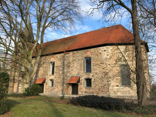 Historische Backsteinkirche in Nendorf, umgeben von Bäumen, charakteristisch für norddeutsche Architektur.