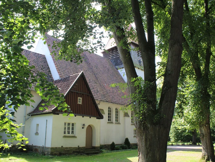Eingebettet in üppiges Grün erhebt sich die historische Kirche Raddestorf mit ihrem markanten Glockenturm.The historic Raddestorf church with its striking bell tower is nestled in lush greenery.Den historiske Raddestorf-kirke med sit markante klokketårn ligger omgivet af frodigt grønt.De historische Raddestorf kerk met zijn opvallende klokkentoren ligt verscholen in het weelderige groen.