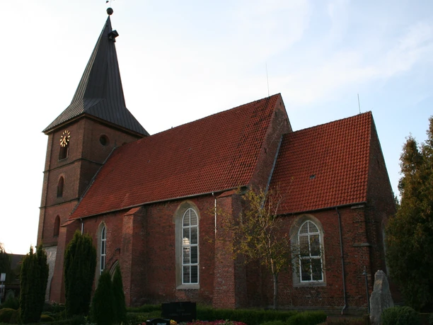 St. Aegidien-Kirche Rodewald Gotische Backsteinkirche mit rotem Satteldach und Turm mit spitzem Helm im Abendlicht.