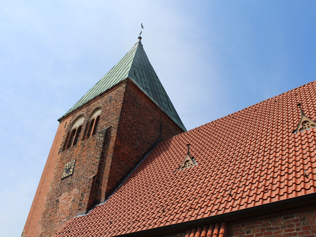 Kirche Riede Kirche Riede mit rotem Ziegeldach und markantem grünen Kirchturm unter blauem Himmel.
