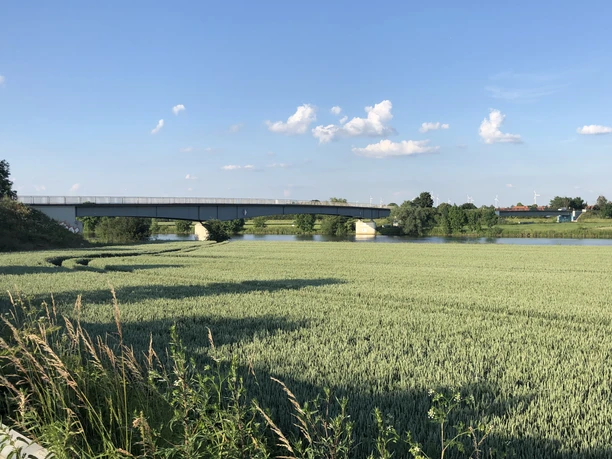 The Weser bridge in Landesbergen spans the river, surrounded by wide fields and blue skies.