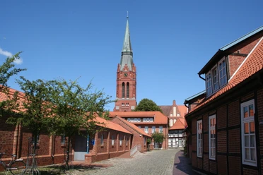 The towering parish church of St. Martin in Nienburg with its red brick and pointed church tower.