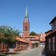 Pfarrkirche St. Martin Nienburg Die hoch aufragende Pfarrkirche St. Martin in Nienburg mit rotem Backstein und spitzem Kirchturm.