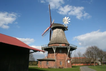 Feldmühle Martfeld Feldmühle Martfeld: Historische Windmühle aus Backstein und Holz in ländlicher Umgebung unter blauem Himmel.