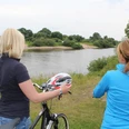 Radler an der Weser Zwei Frauen stehen mit Fahrrädern am Weserufer, blicken auf den ruhigen Fluss und die Natur.
