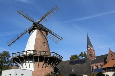 Windmühle Lahde Windmühle in Lahde mit markantem Backsteinbau und grauen Flügeln, umgeben von historischen Häusern.