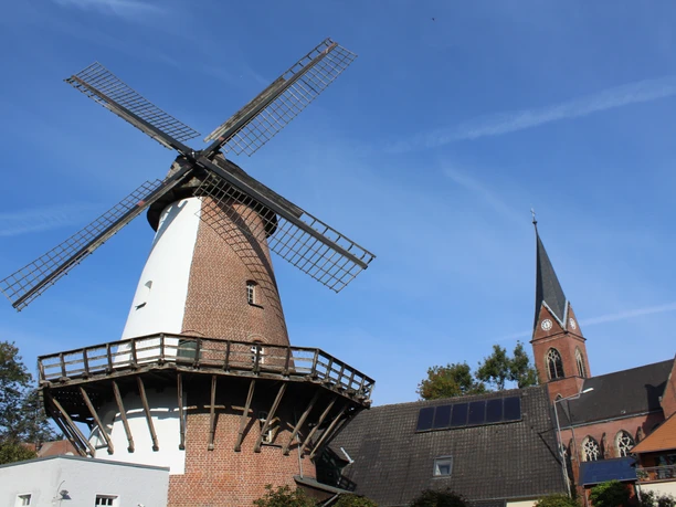 Windmühle Lahde Windmühle in Lahde mit markantem Backsteinbau und grauen Flügeln, umgeben von historischen Häusern.