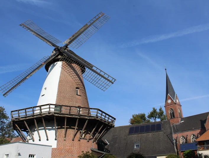 Windmühle Lahde Windmühle in Lahde mit markantem Backsteinbau und grauen Flügeln, umgeben von historischen Häusern.